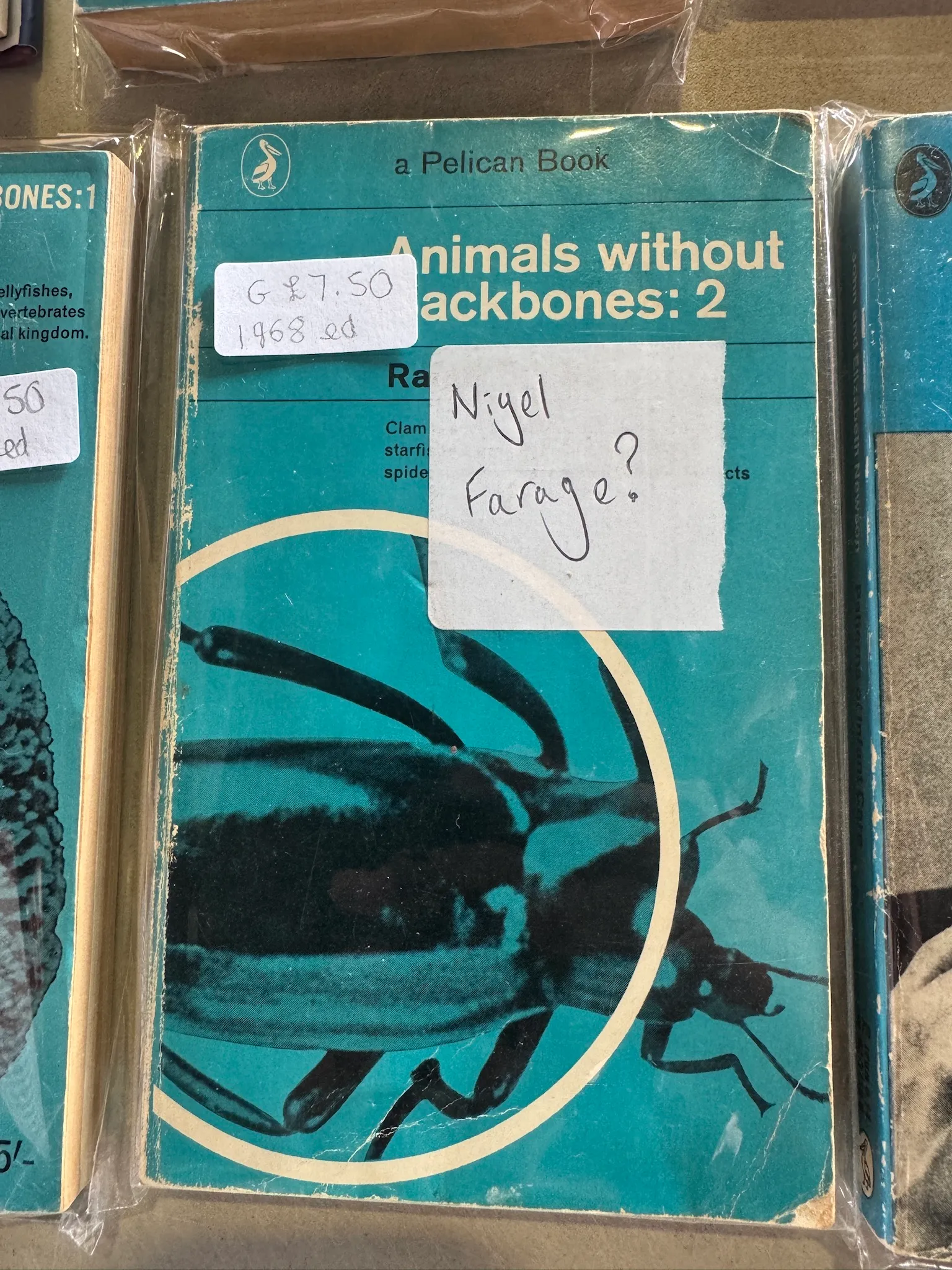 A copy of the book “Animals without backbones: 2”, with price label of £7.50 pasted on it. There is post-it note underneath the book title that reads “Nigel Farage?”. 