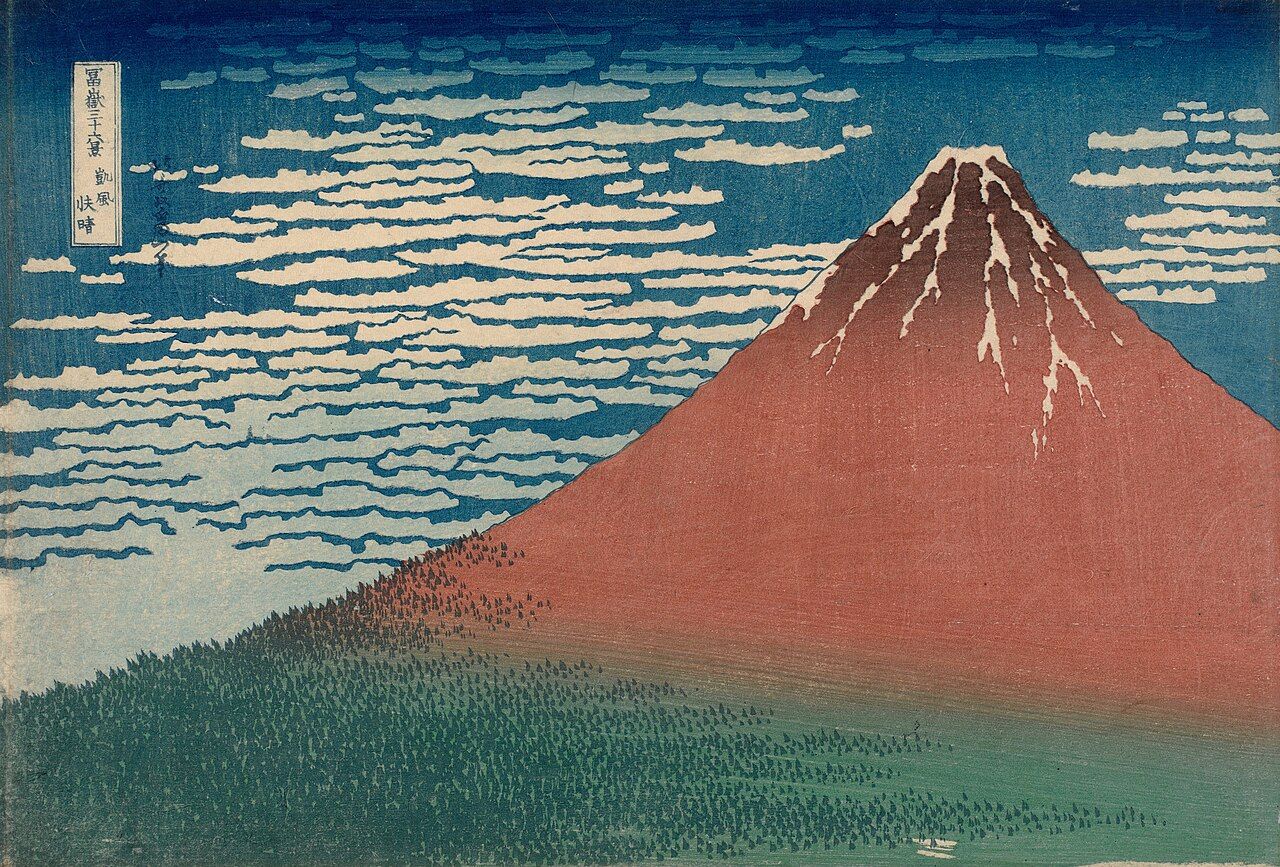 Woodblock print of Mount Fuji, drawn here in a reddish hue, with green trees speckled along its base.