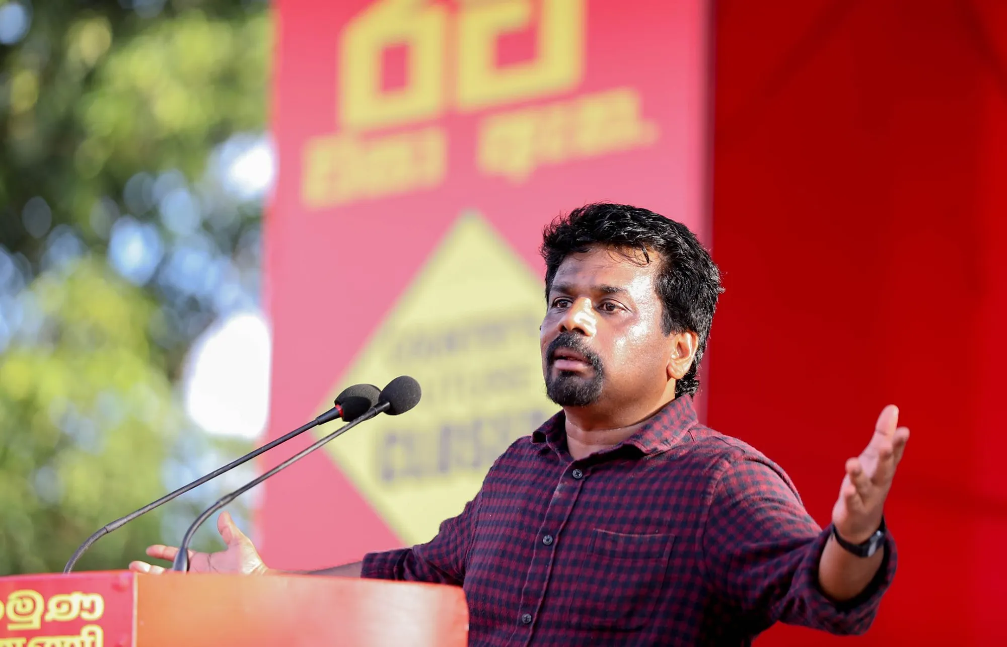 Anura Kumara Dissanayke on stage speaking into a mic