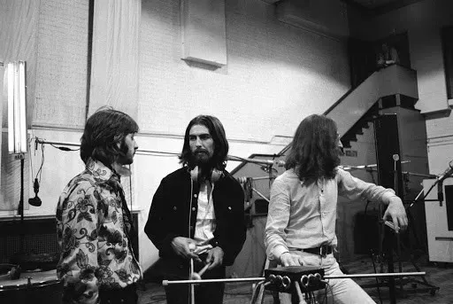 From left to right, Ringo, George, and John, standing among some of their recording gear