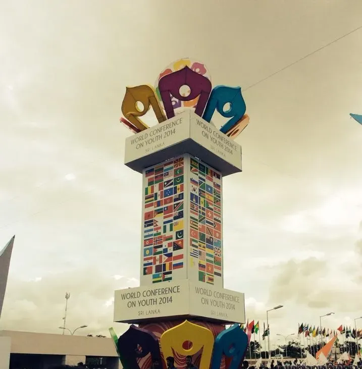 A large obelisk-like structure decorated with flags of various countries