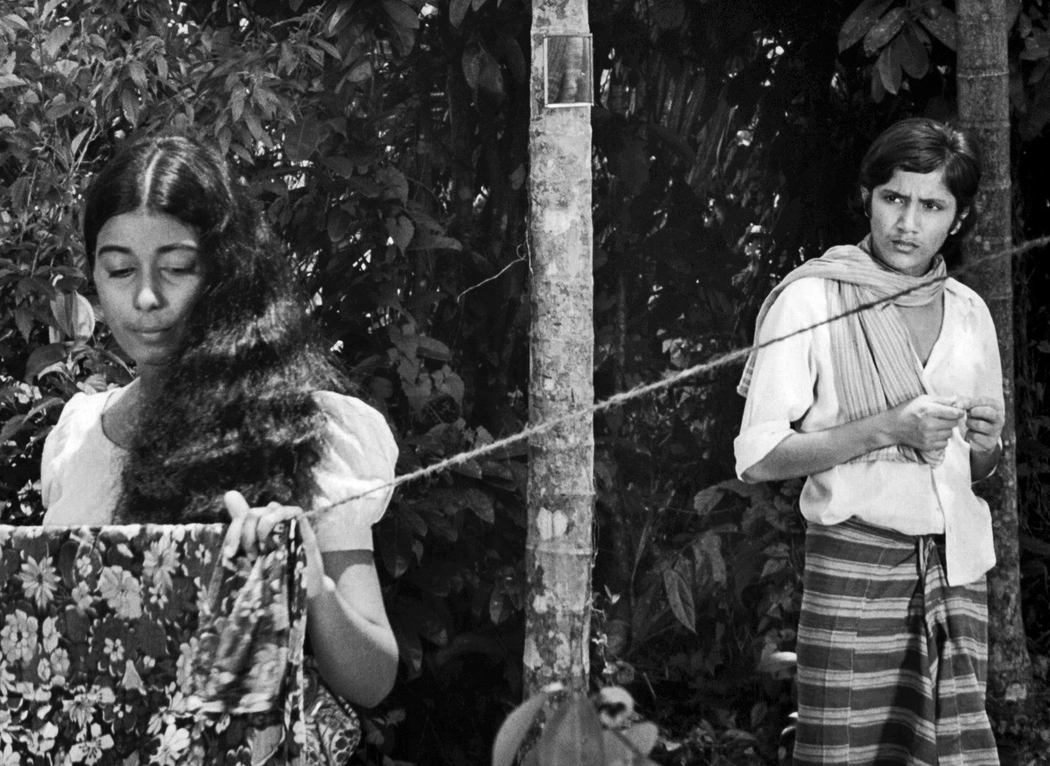 A still from the film. Wasanthi Chathurani, playing Kusum, is on the left of the frame while Ajith Jinadasa, playing Nimal, is on the right, looking at her.