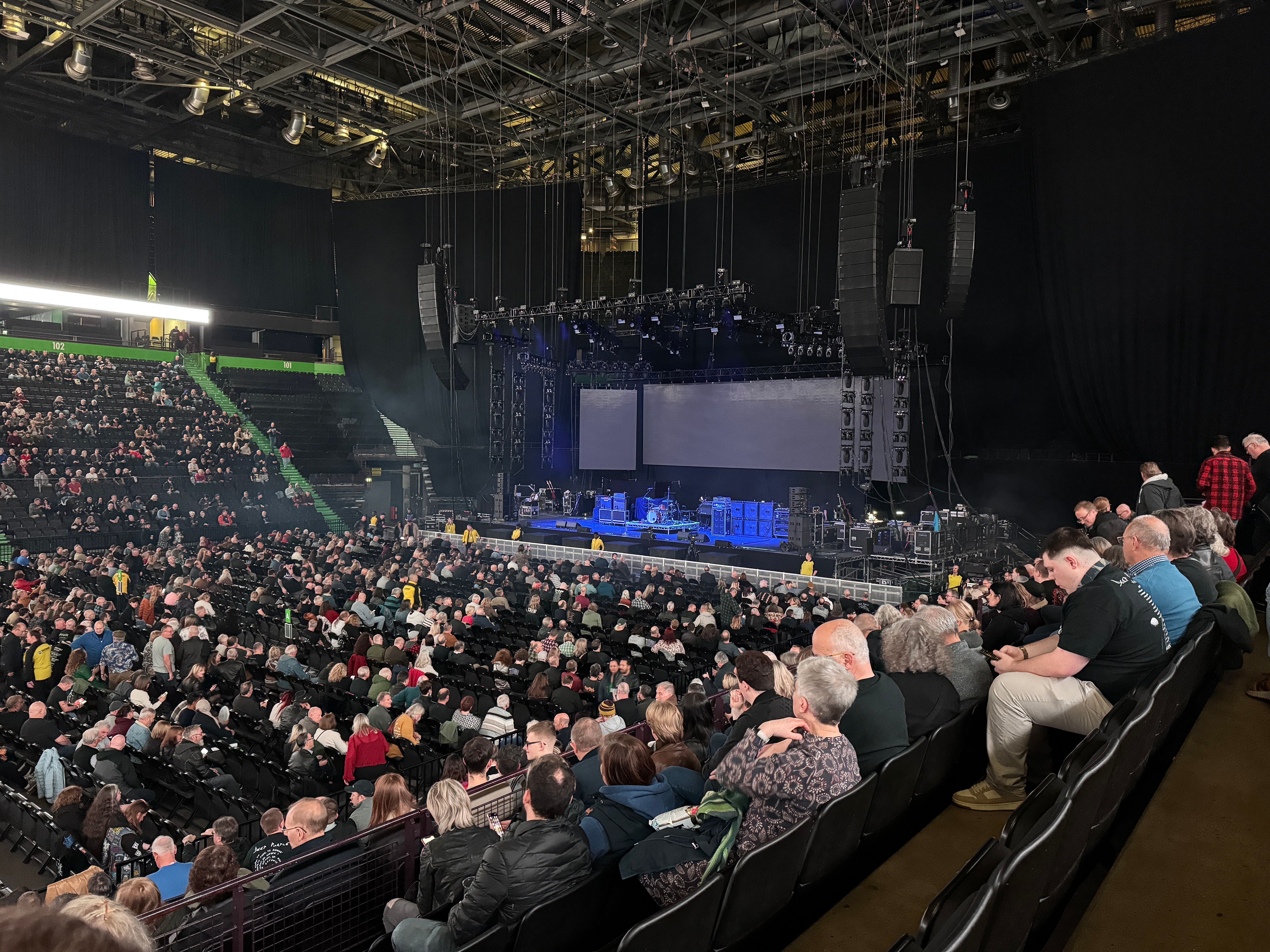 A large empty stage with people sat in the audience