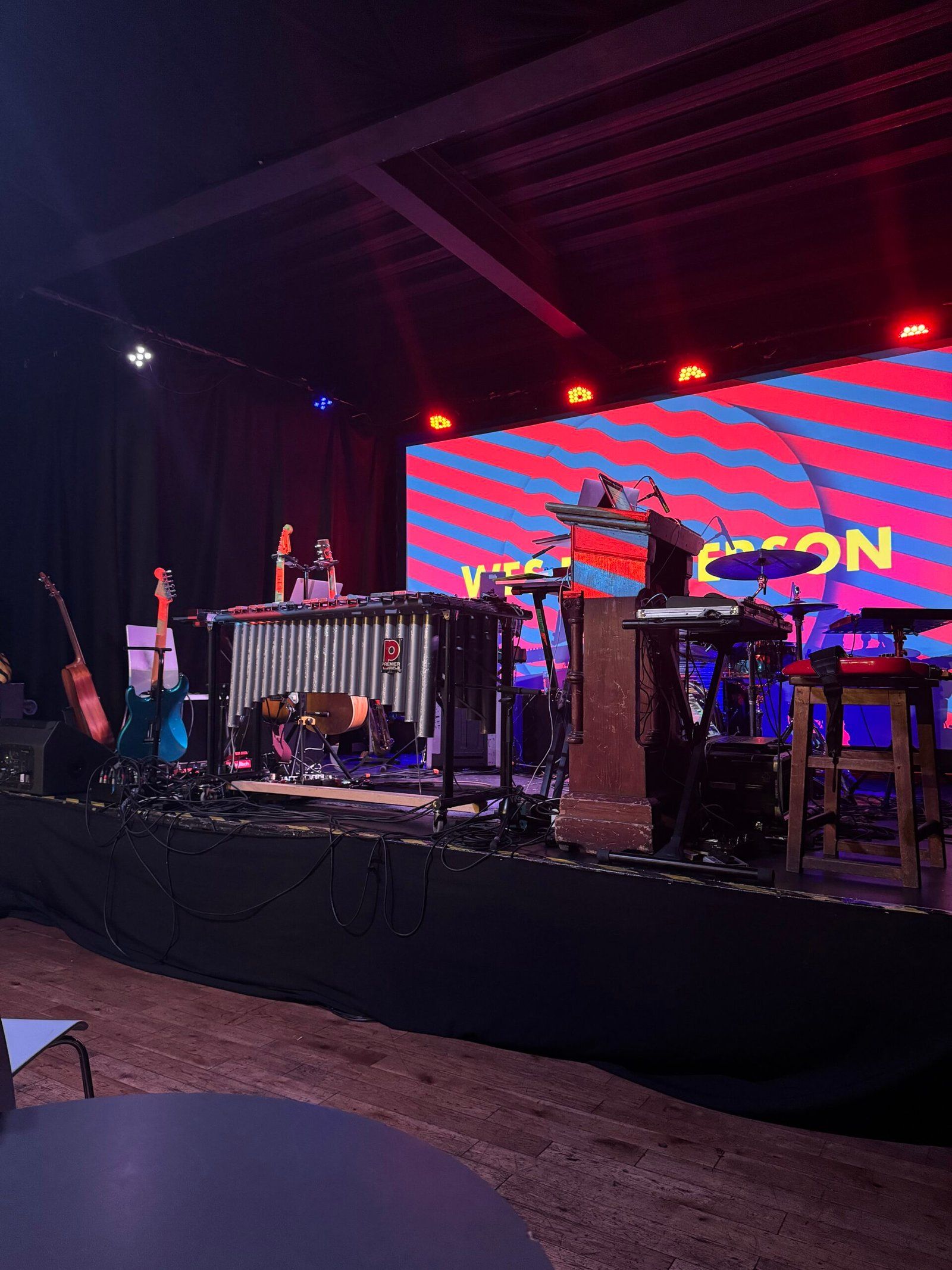 A photo of all the gear on stage, just before the band went on. There is a large screen at the back with their logo on it.