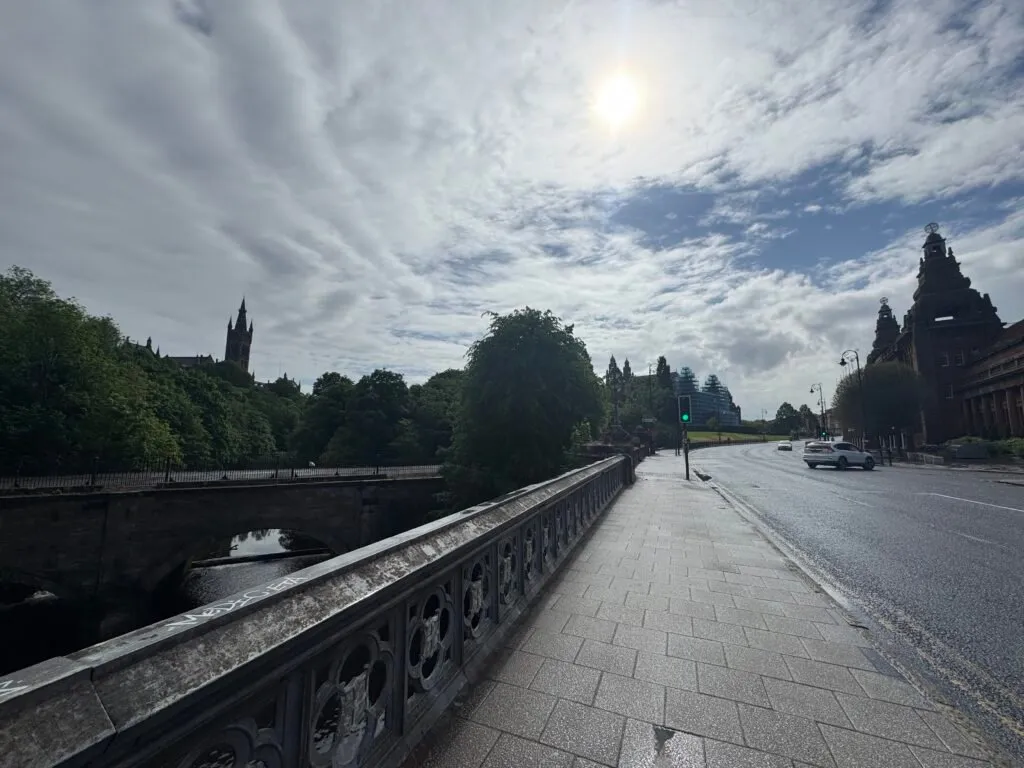 Glasgow’s Argyle Street after the rain, with the Kelvingrove art gallery barely visible through the trees on the left and Kelvin Hall on the right.