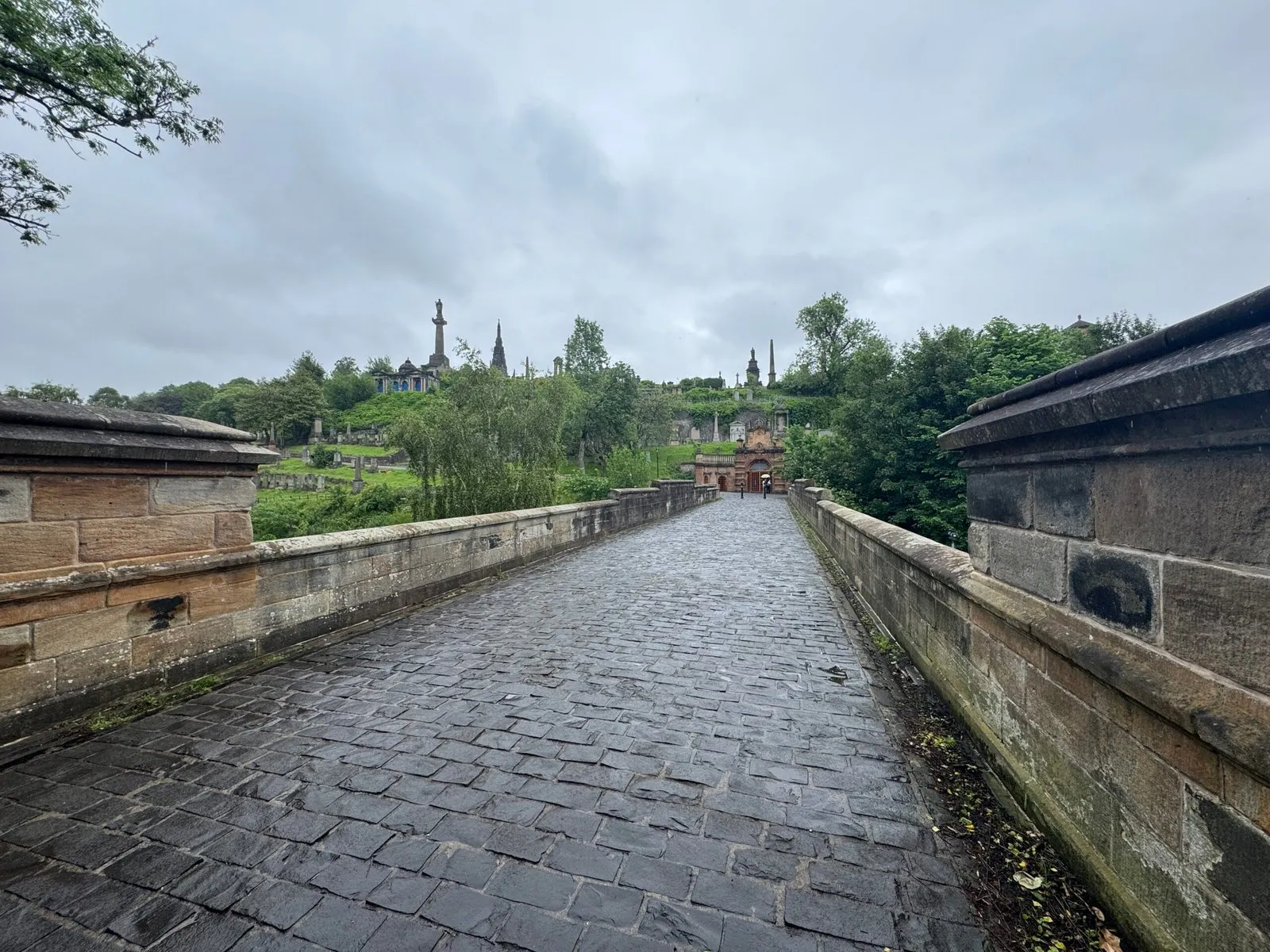 A photo of the bridge that marks the entrance to the necropolis. Large monuments can be seen in the background.