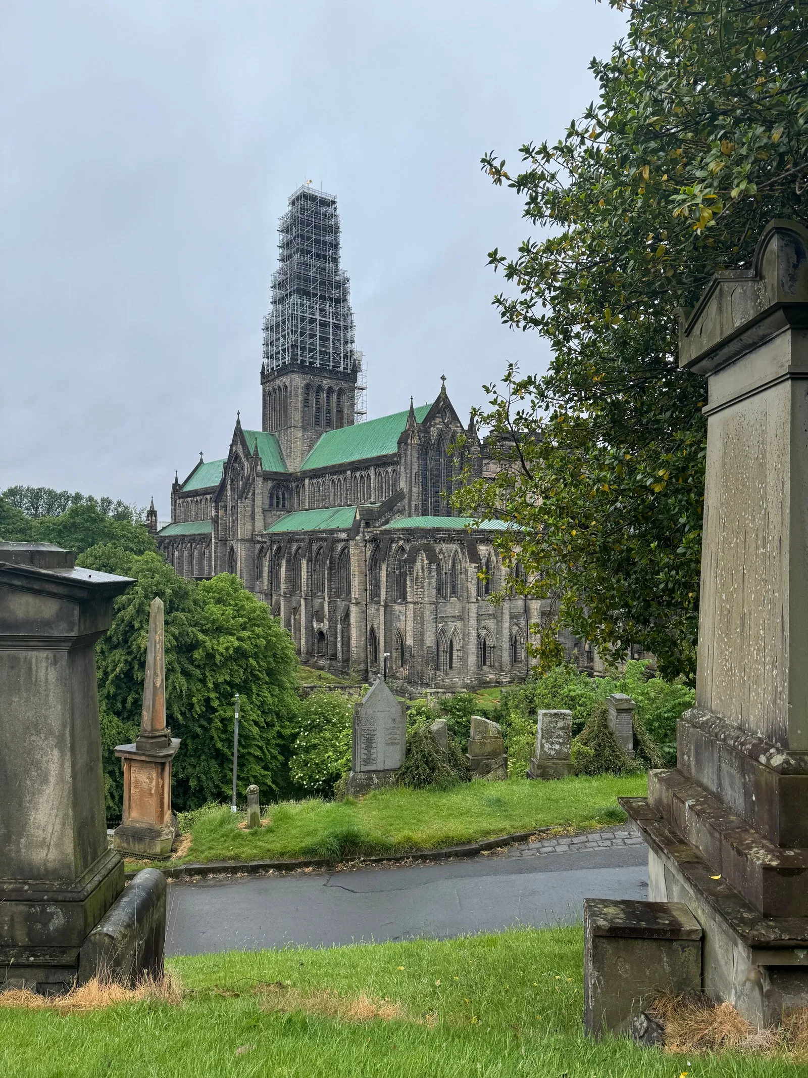 The Glasgow Cathedral as seen from the necropolis, through tombstones and trees