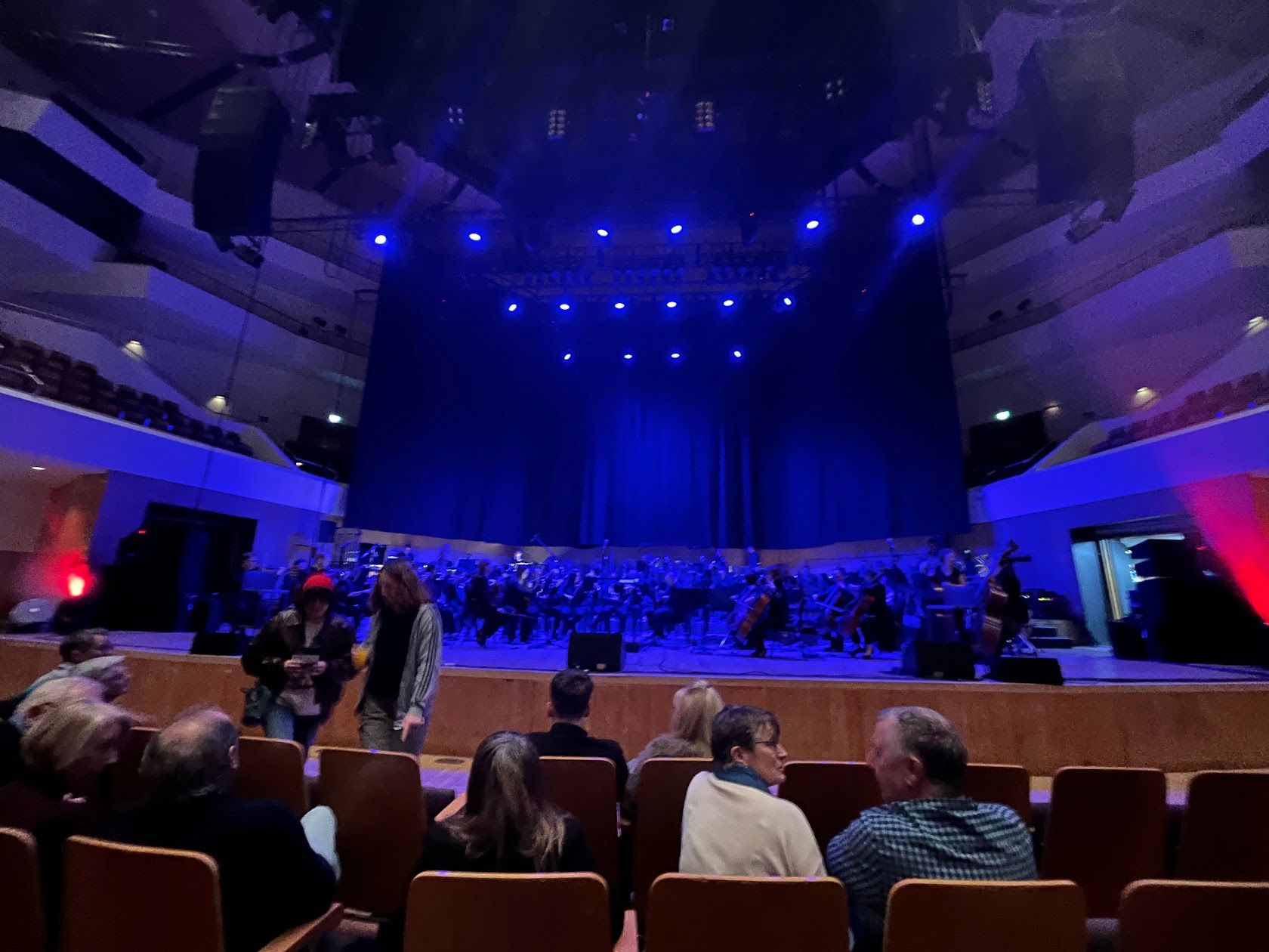 The musicians getting ready for the gig, on a stage lit in blue