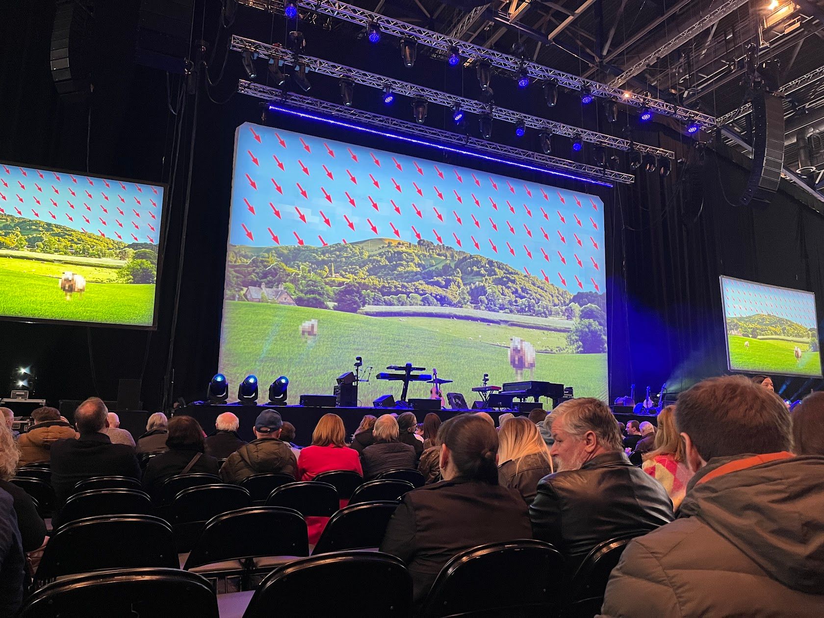 A stage, with 3 large LED screens on it