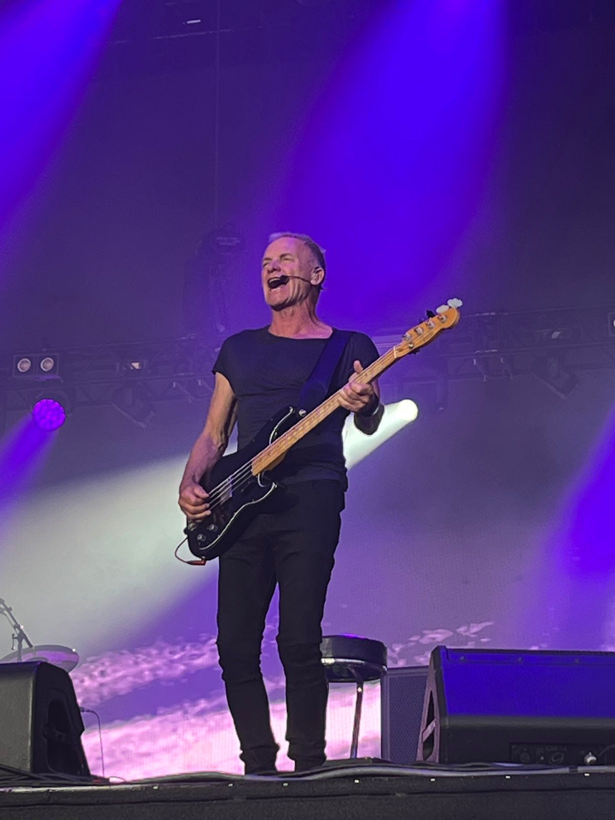 Sting playing bass and singing on stage