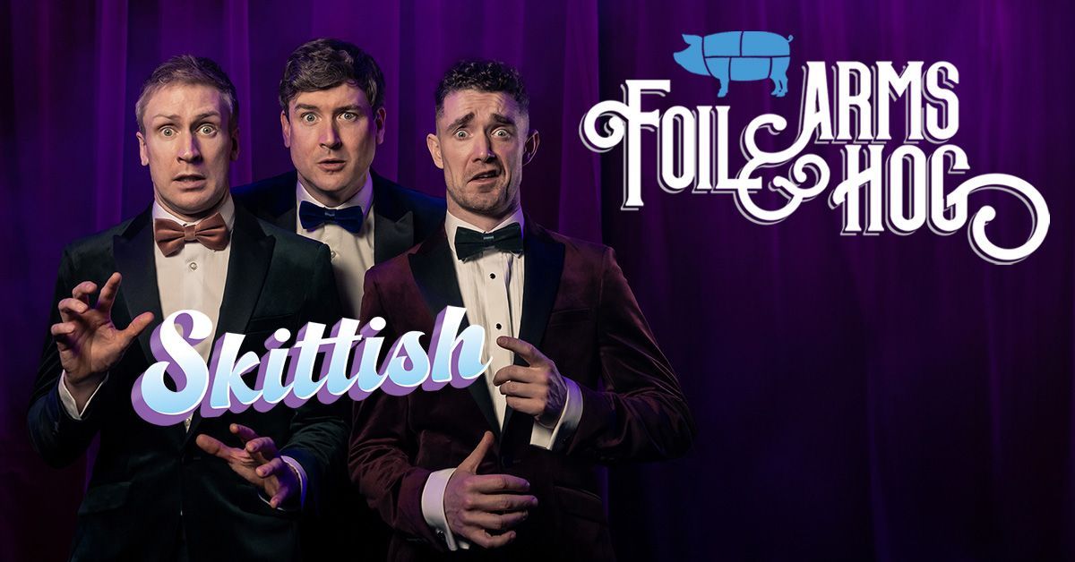 A promotional photo of the comedy trio; they're wearing tuxedos and making comedic poses.